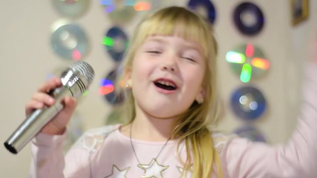 A child with a microphone sings and dances