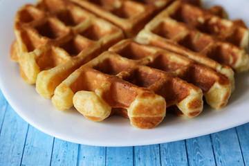 Belgian waffles on white plate. Healthy breakfast close up, freshly baked classic wafer