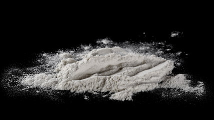 Wheat flour pile isolated on black background, powder texture