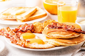 Healthy Full American Breakfast with Eggs Bacon Pancakes and Latkes.