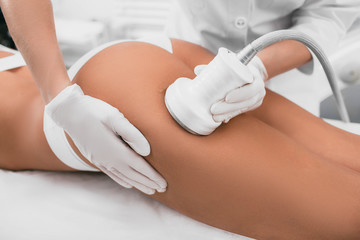 woman having cavitation, procedure removing cellulite on her buttocks , lifting buttocks - obrazy, fototapety, plakaty