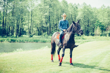 Brave man riding a horse in the farm in cowboy style. Sport, happiness, hobby concept