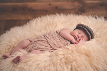 Close up süßes Neugeborenes Baby Junge mit Mütze schläft friedlich auf Fell