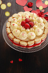 Cake with butter cream and fresh raspberries for Valentine's Day or mother's day on black wooden background,