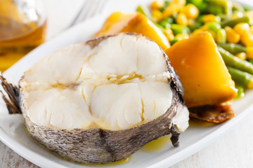 boiled fish with vegetables on white dish