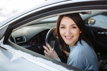 Happy woman driving a car outdoors in winter