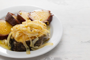 boiled fish with onion and sweet potato on white dish
