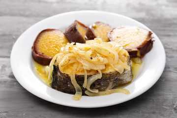 boiled fish with onion and sweet potato on white dish