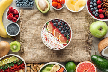 top view of smoothie bowls and frame made of fresh ingredients on sackcloth