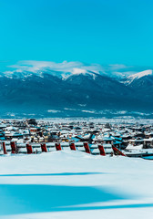 Fototapeta na wymiar Mountain snow peak, Alpine village houses. Europe, old town winter ice hill top panoramic view.