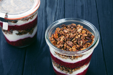Close up view on healthy Homemade Granola Parfait in jar with jam. Quick Healthy Breakfast Greek Yogurt Parfait. Selective focus. free copy space. Menu photo. Vegetarian food lifestyle
