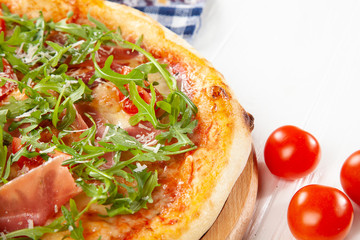 Close up view on pizza on white wooden background with ingridients.  Restaurant, food menu, recipe, cafe concept. Lifestyle food. Italian cuisine with free copy space. Menu photo. Italian fast food