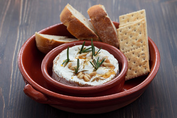 cheese camembert with nuts and rosemary in ceramic dish