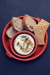 cheese camembert with nuts and rosemary in ceramic dish