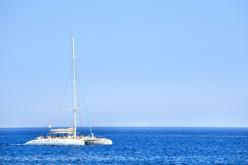 Obraz premium Catamaran with tourists with blue sky and water. Vacation background.