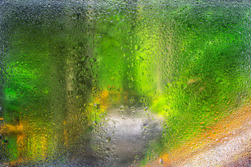 Water droplets on a window pane with beautiful defocused scenery outside.