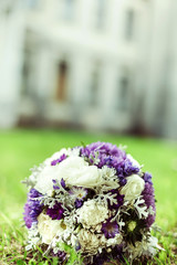 Bouquet of flowers in hands of young elegant girl outdoors. Wedding flowers