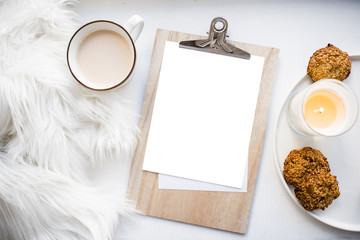 Obraz na płótnie Canvas Cozy home arrangement with coffee cup and blank clipboard mockup