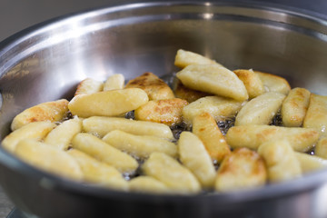 Sticks of dough and potatoes fry with butter in a frying pan
