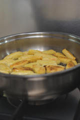 Sticks of dough and potatoes fry with butter in a frying pan