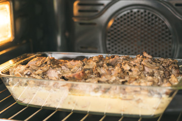 meat with mushrooms and gravy is cooked in the oven