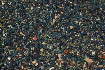 beach of dark colored stones close up, texture