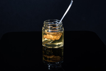 truffle mushroom in a jar of honey on a black background. Minimalism in composition. Luxury food. Free space for text.