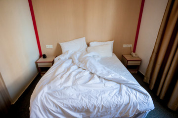 Fototapeta na wymiar Crumpled bed in the hotel