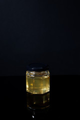 truffle mushroom in a jar of honey on a black background. Minimalism in composition. Luxury food. Free space for text.