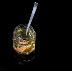 truffle mushroom in a jar of honey on a black background. Minimalism in composition. Luxury food. Free space for text.