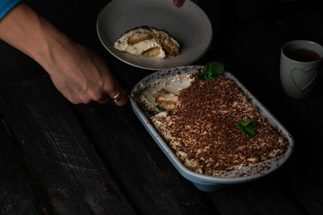 homemade Tiramisu, dark style, female hand