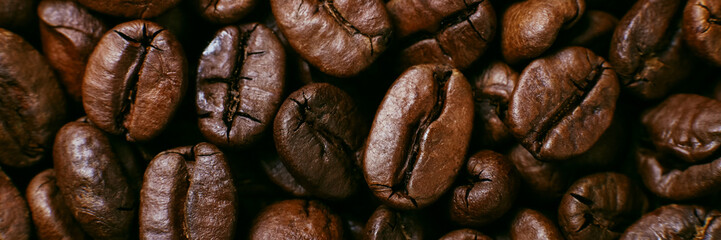 Aroma roasted coffee beans, brown banner background. Soft focus close up.