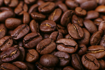 Naklejka premium Aroma roasted coffee beans, brown background. Soft focus close up.