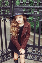 Obraz na płótnie Canvas Outdoor portrait of teenage girl in stylish look, in black hat posing outdoors in park