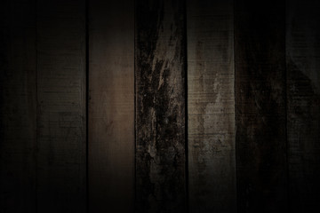 Dark background and wallpaper or texture of panel wood material wall color old abrasive for decorative vintage style has dim light and copy space.