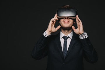 smiling businessman in virtual reality headset isolated on black