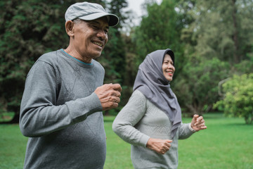 Fototapeta premium couple doing exercising by running in the garden 