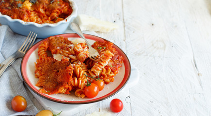 Plate with baked pasta with tomato sauce and mozzarella cheese