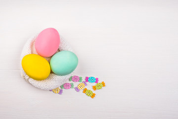 Colored eggs lie on a light wooden background, Concept illustration for Easter