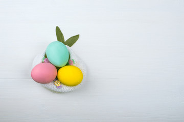 Colored eggs lie on a light wooden background, Concept illustration for Easter