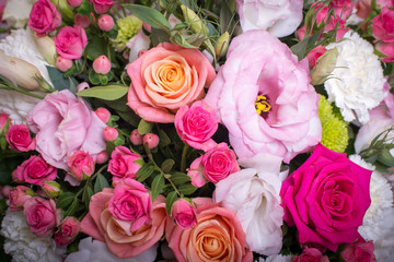 beautiful floral arrangement in the box, pink and yellow rose, pink eustoma, green and pink chrysanthemum, white carnation, pink dahlia on pink background with space for text.