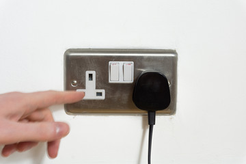 Finger going in electrical plug socket. Safety concept