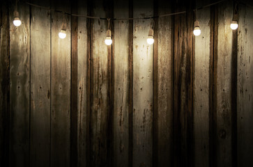 Low key image Old wood background with dim light from light decorated with bulbs and copy space...
