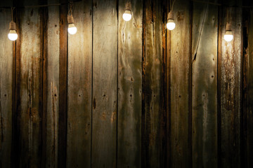 Low key image Old wood background with dim light from light decorated with bulbs and copy space...