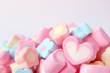 Closed Up a Pink and White Heart Shaped Marshmallow on the Pile of Pastel Color Flower Shaped Marshmallow Candies 