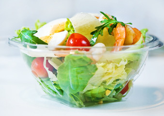 Delicious Caesar salad with shrimps, tomatoes and arugula on white
