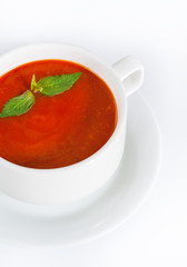 Delicious red tomato soup in bowl on white