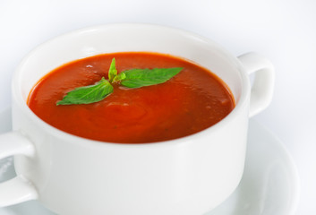 Delicious red tomato soup in bowl on white