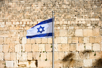 (focus on the flag) Close-up view of the Israeli flag waved by the wind and the  the blurred...