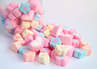 Pink Heart Shaped Marshmallow on the Pile of Pastel Flower Shaped Marshmallow with some in the Glass Jar in Background 